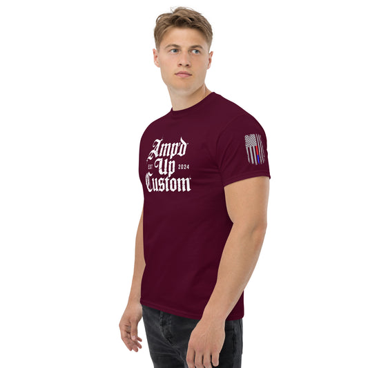 Male model wearing maroon Amp'd Up Custom EST2024 T-Shirt with white gothic logo on chest and flag sleeve patch