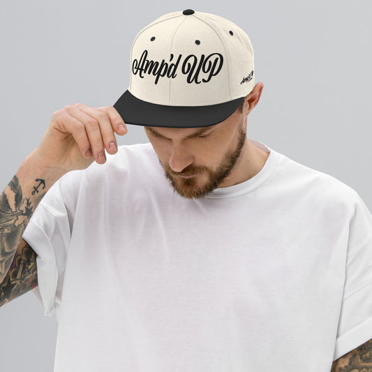 Man wearing Amp'd Up cursive 3D Puff Snapback Hat in cream and black for stylish headwear