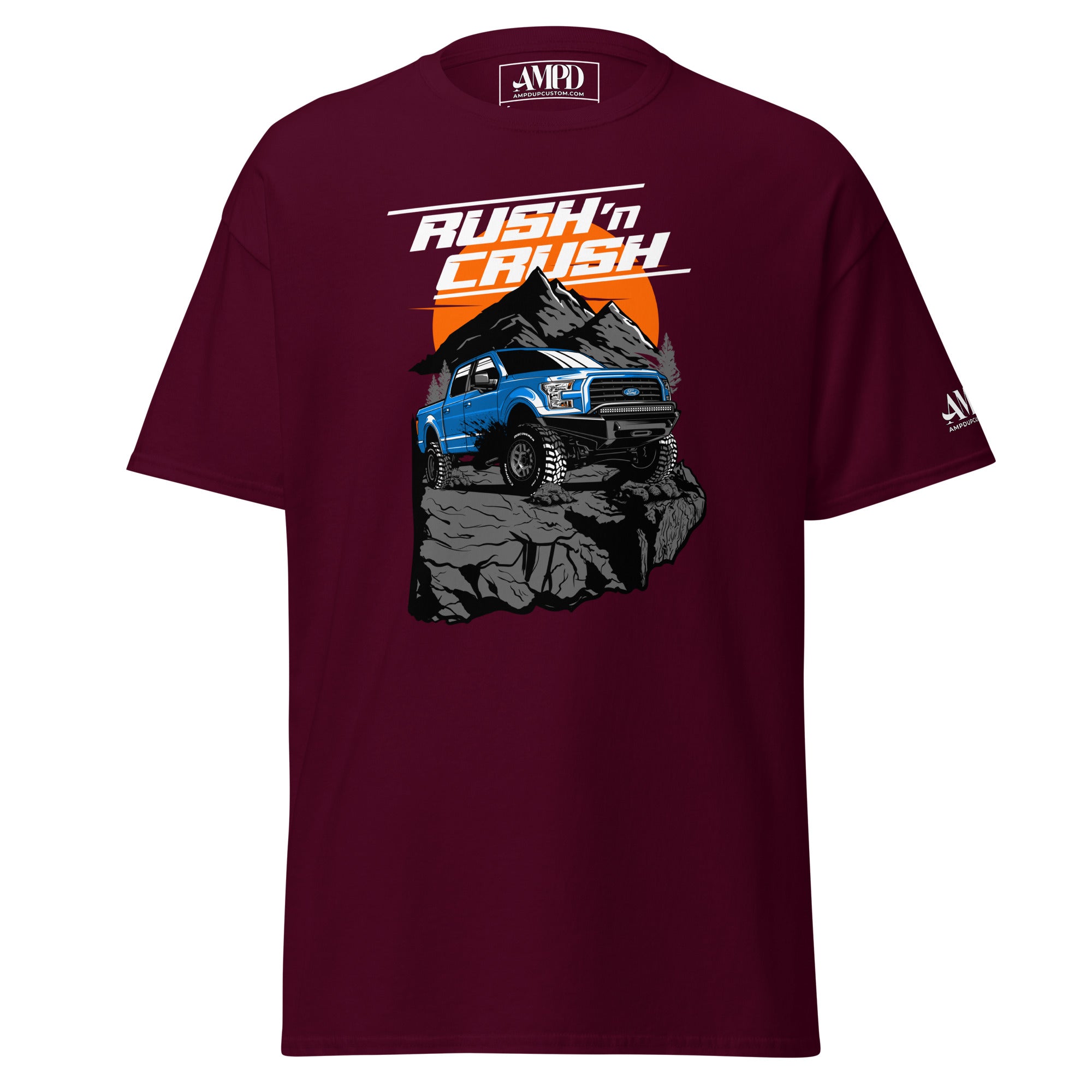 Rush n Crush Off-Road T-Shirt | AMPD featuring a blue truck on rocky terrain with mountains in the background