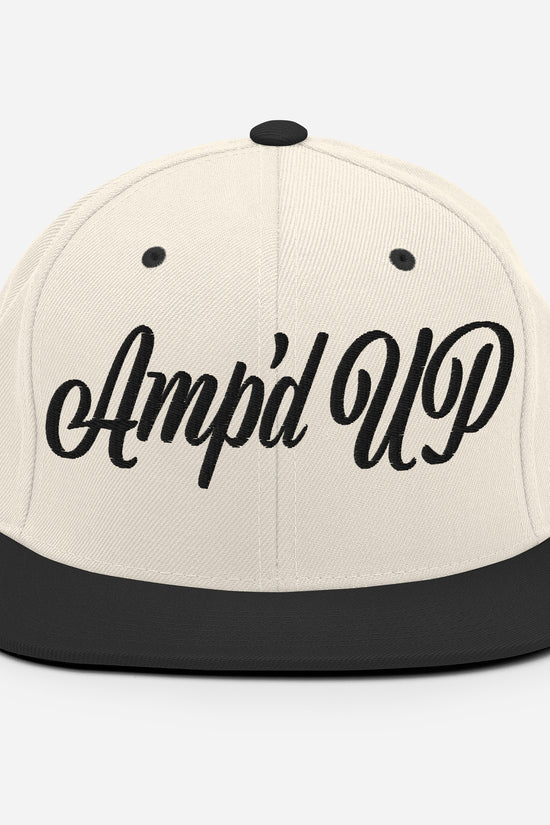 Amp'd Up cursive 3D Puff Snapback Hat in cream and black with stylish embroidered logo