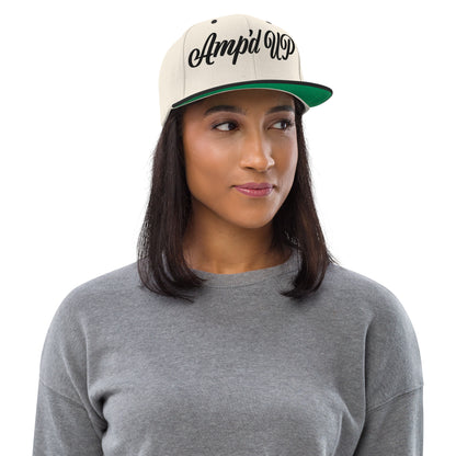 Woman wearing an Amp'd Up cursive 3D Puff Snapback Hat in beige with black lettering