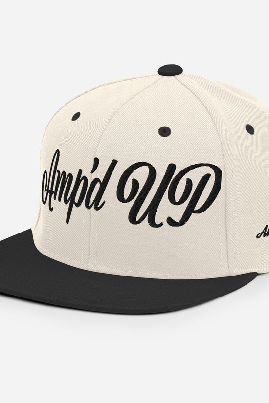 Amp'd Up cursive 3D Puff Snapback Hat in beige and black with stylish embroidered logo