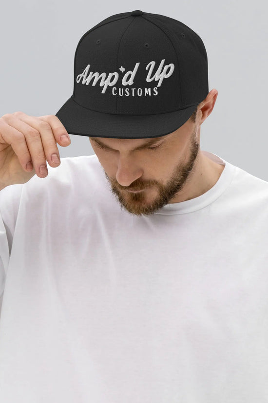 Man wearing an Amp'd Up Custom Snapback Hat in black showcasing stylish logo design