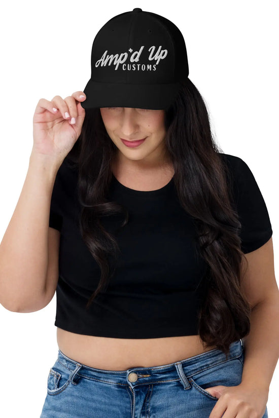 Woman wearing an Amp'd Up Embroidered Trucker Cap with a black crop top and stylish jeans