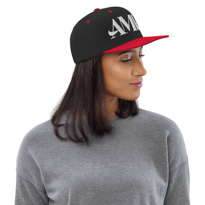 Ampd Up Logo Snapback hat in black and red worn by a model with a gray sweater