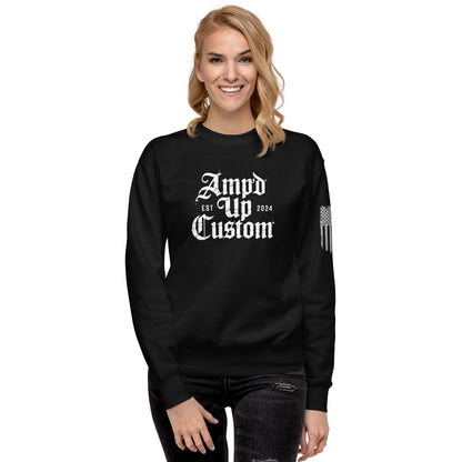 A smiling woman wearing a black Amp'd Up Custom EST2024 Sweatshirt with white gothic logo and flag sleeve print