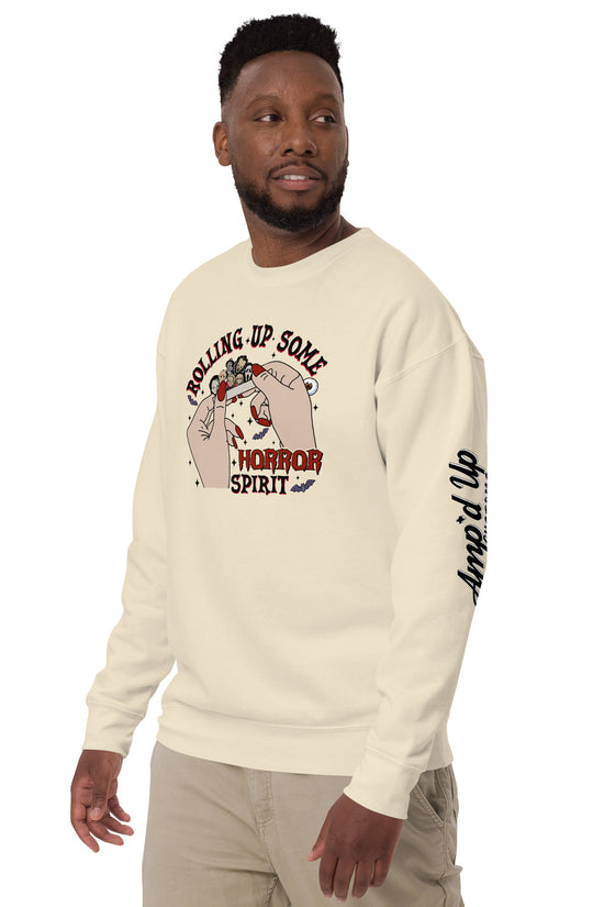 Man wearing a cream sweatshirt with Rolling Up Some Horror Spirit Sweatshirt graphic and amped up text on sleeve