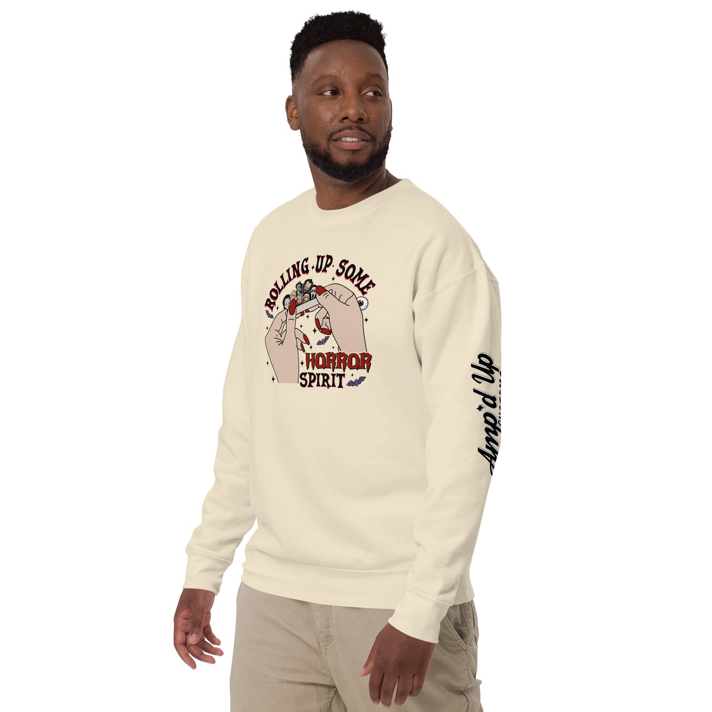 Man wearing a cream sweatshirt with Rolling Up Some Horror Spirit Sweatshirt graphic and amped up text on sleeve