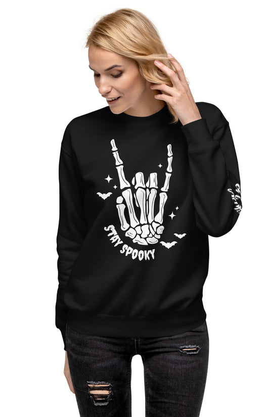 Woman wearing black Stay Spooky Sweatshirt with skeleton hand and bats graphic from Amp'd Up Custom