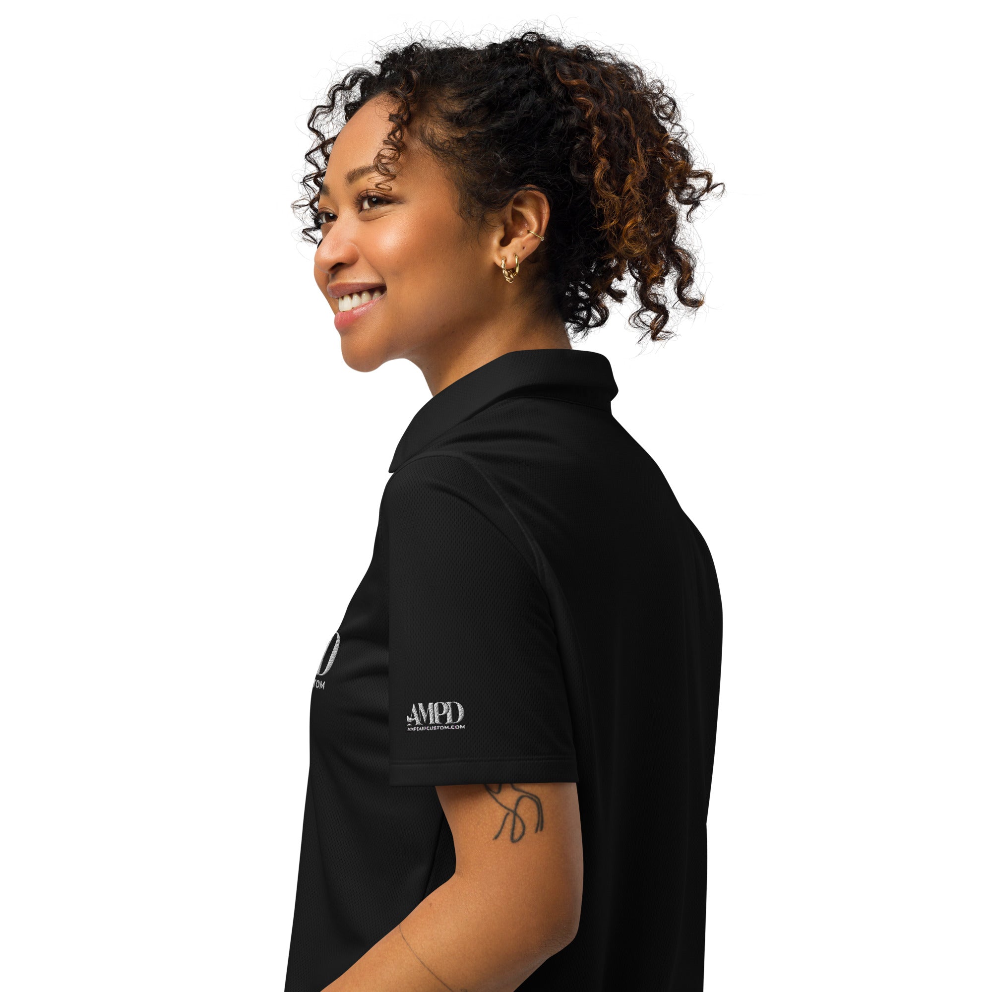Side view of a woman wearing the AMPD Official Under Armour Womens polo in black