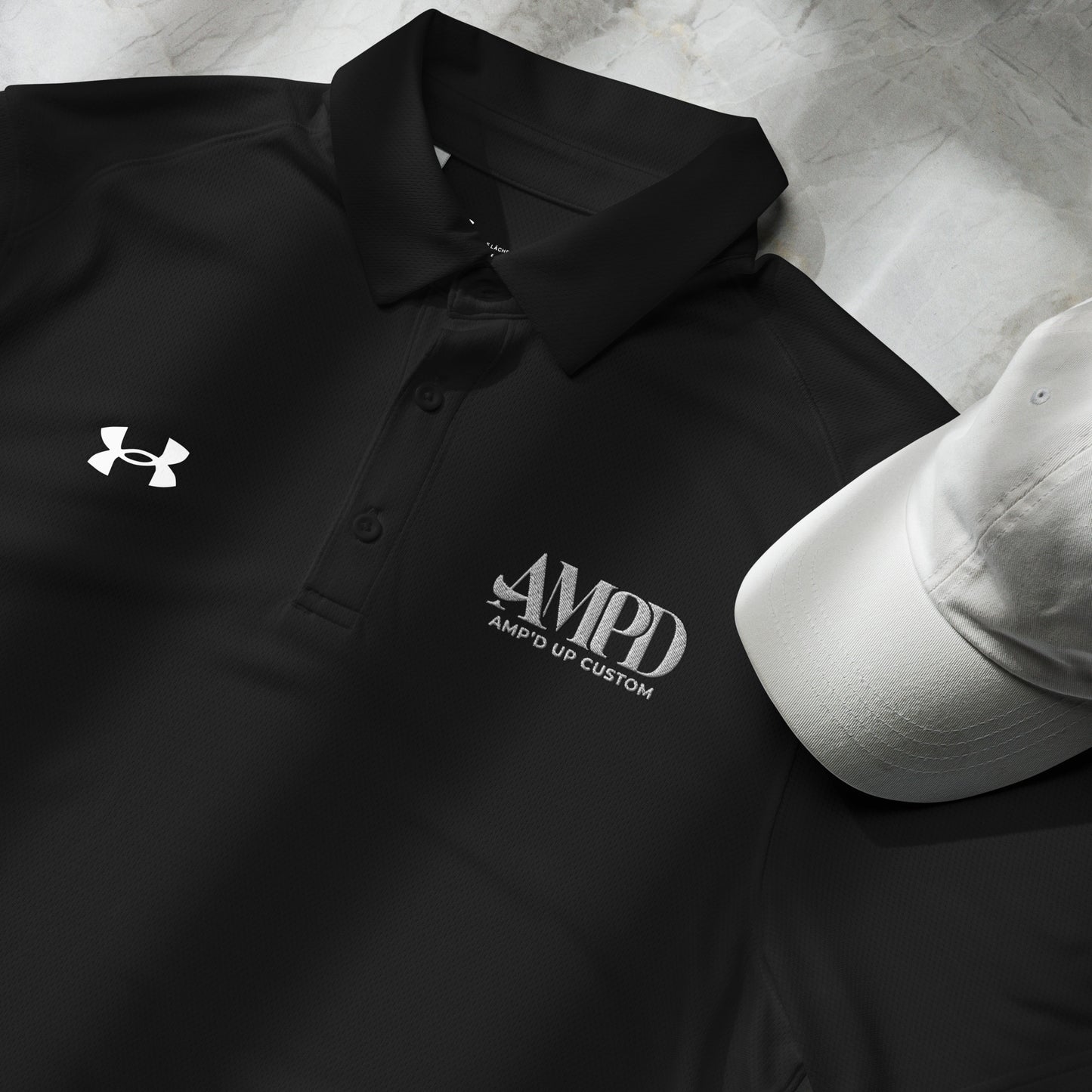 Amp'd Up Official Under Armour Men's Polo in black with embroidered logo and white cap
