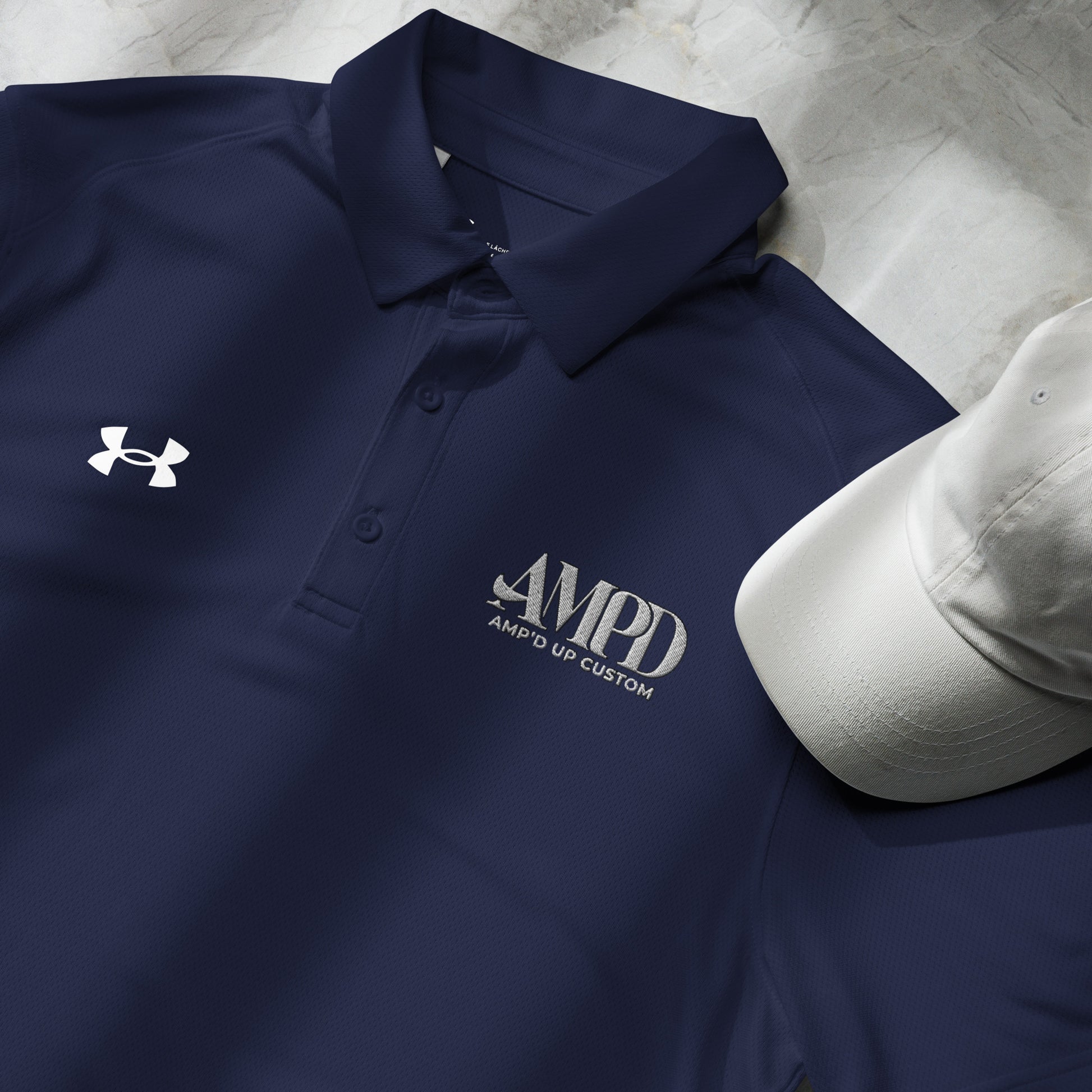 Amp'd Up Official Under Armour Men's Polo in navy blue featuring logo and matching white cap